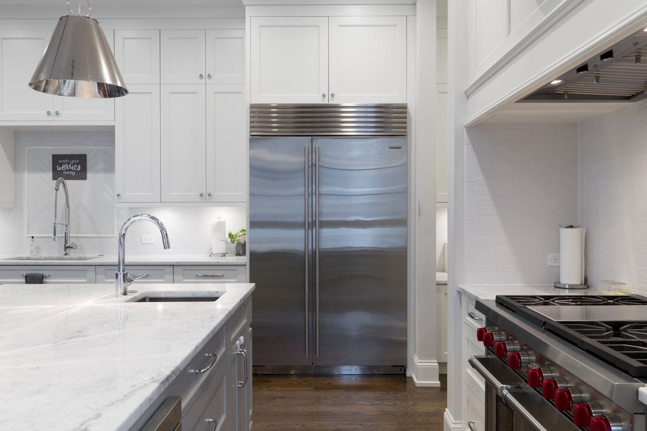 portfolio-03 A sleek modern kitchen featuring stainless steel appliances and marble countertops.