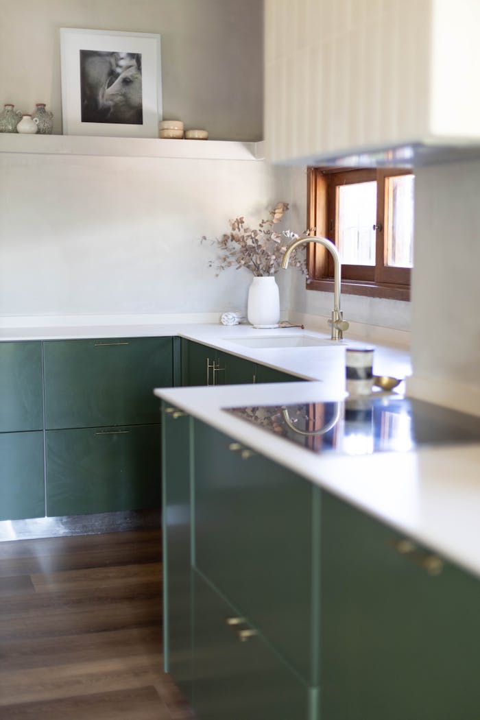 portfolio-01 Modern kitchen interior with green cabinets, white countertops, and natural light.